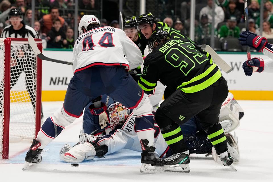 Columbus Blue Jackets defenseman Erik Gudbranson (44) and goaltender Elvis Merzlikins, bottom, defend against the puck in front of the net as Dallas Stars' Matt Duchene (95) looks for a shot-opportunity in the first period of an NHL hockey game, Monday, Oct. 30, 2023, in Dallas. (AP Photo/Tony Gutierrez)
