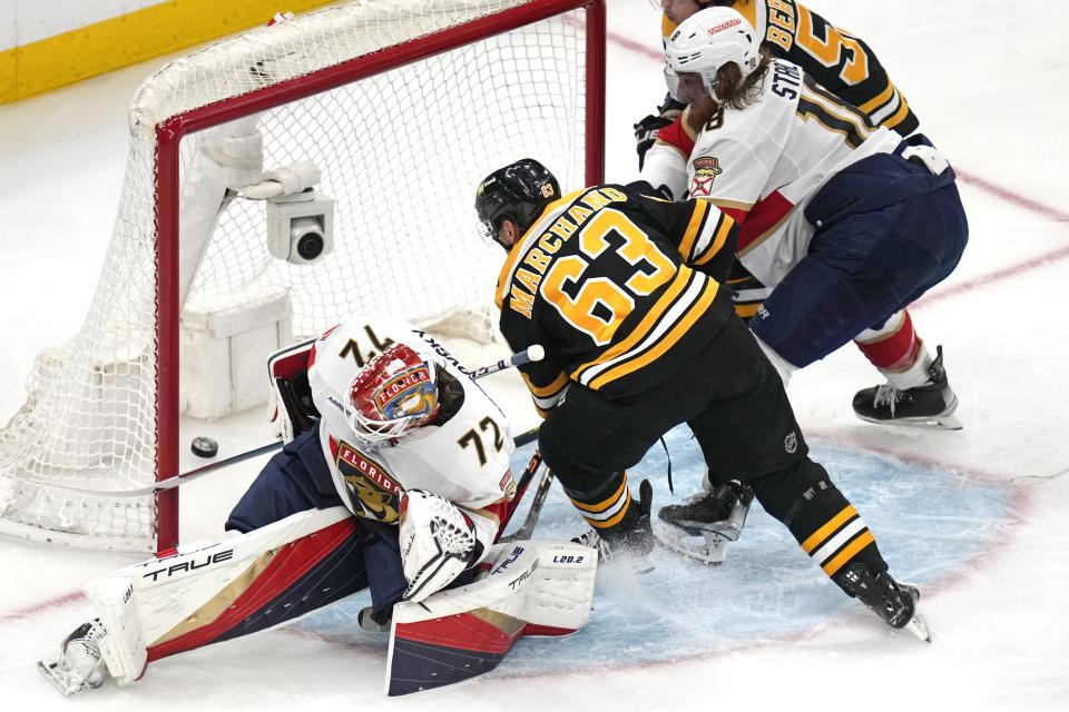 Boston Bruins left wing Brad Marchand (63) follows his shot and scores after a save by Florida Panthers goaltender Sergei Bobrovsky (72) during the second period of Game 5 in the first round of the NHL hockey playoffs, Wednesday, April 26, 2023, in Boston. At right is Florida Panthers defenseman Marc Staal. (AP Photo/Charles Krupa)