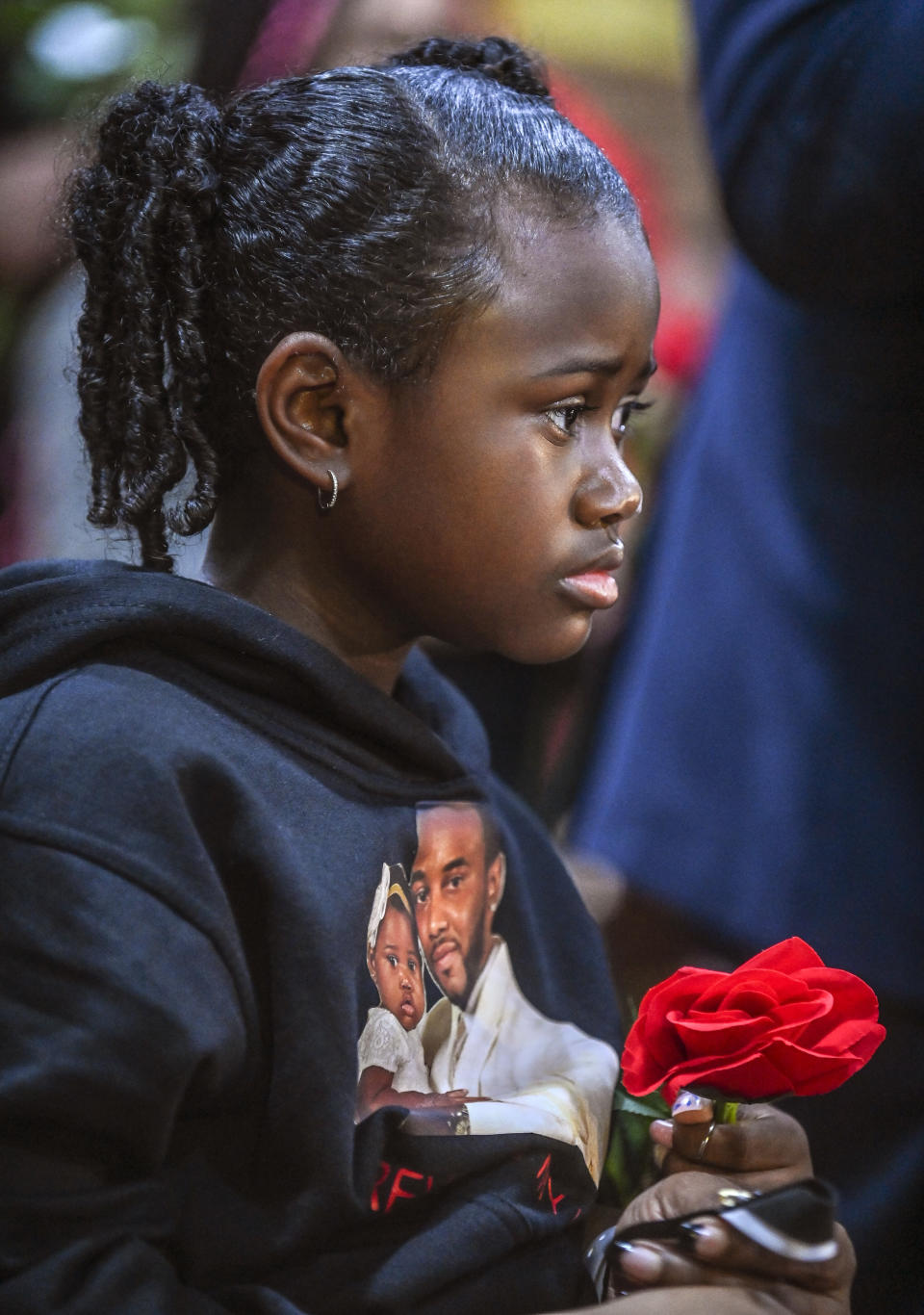 Avani Perkins holds a rose during a vigil for her father, Stephen Perkins, outside Decatur, Ala. City Hall/Police Department, Thursday, Oct. 5, 2023. Police shot and killed Perkins, 39, the week before in what began in an early morning confrontation with a tow truck driver trying to repossess a vehicle, police said. Perkins' family said that he was not behind on payments and the vehicle should not have been repossessed. (Jeronimo Nisa/The Decatur Daily via AP)