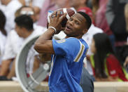 Oklahoma City Thunder guard and UCLA alum Russell Westbrook throws a football around on the sidelines of an NCAA college football game between UCLA and Oklahoma in Norman, Okla., Saturday, Sept. 8, 2018. (AP Photo/Sue Ogrocki)