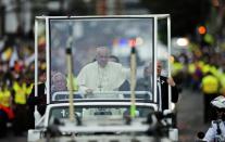 Pope Francis waves as he travels on the Popemobile along the streets of Quito on July 5, 2015