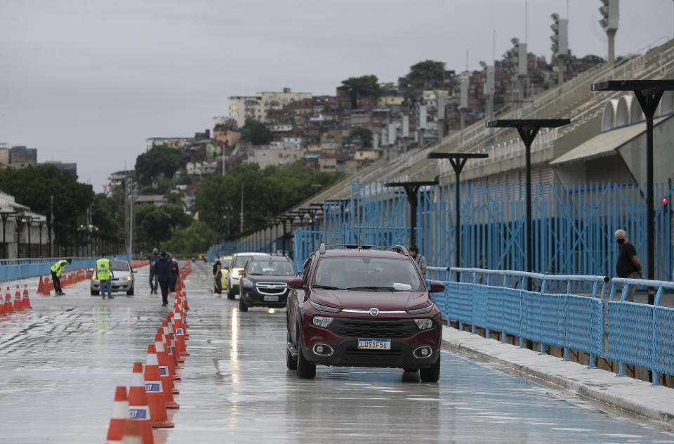 Adultos mayores hacen fila en sus autos mientras esperan ser vacunados en el Sambódromo de Río de Janeiro, el sábado 6 de febrero de 2021. En un año normal, el Sambódromo de Río se estaría preparando para su gran momento del año: el desfile de carnaval más famoso del mundo, pero una semana antes de lo que debería ser el comienzo del Carnaval, la pandemia ha reemplazado al desfile. (AP Foto/Bruna Prado)