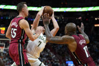 Milwaukee Bucks guard Grayson Allen (7) goes to the basket as Miami Heat guard Duncan Robinson (55) and forward P.J. Tucker (17) defend during the first half of an NBA basketball game Thursday, Oct. 21, 2021, in Miami. (AP Photo/Lynne Sladky)