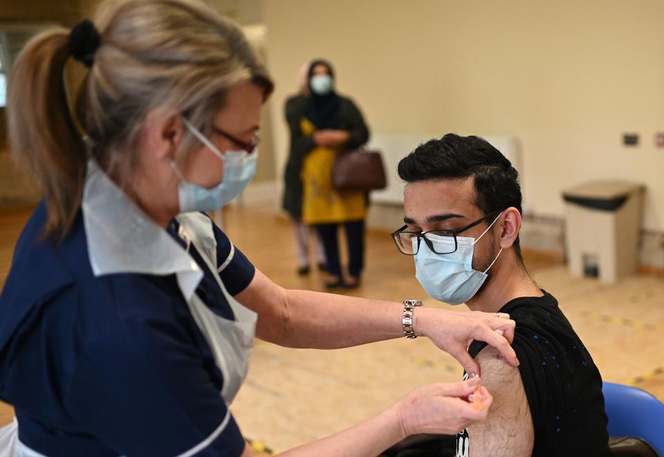 Nurse Maggie Clark administers a dose of the AstraZeneca/Oxford Covid-19 vaccine to a patient at a vaccination centre set up at the Fiveways Islamic Centre and Mosque in Nottingham, central England, on February 22, 2021. - Coronavirus vaccines do not contain pork or make you infertile: a celebrity advertising pitch is striving to counter a worrying lag among certain ethnic minorities affecting Britain's otherwise impressive inoculation campaign. (Photo by Oli SCARFF / AFP) (Photo by OLI SCARFF/AFP via Getty Images)