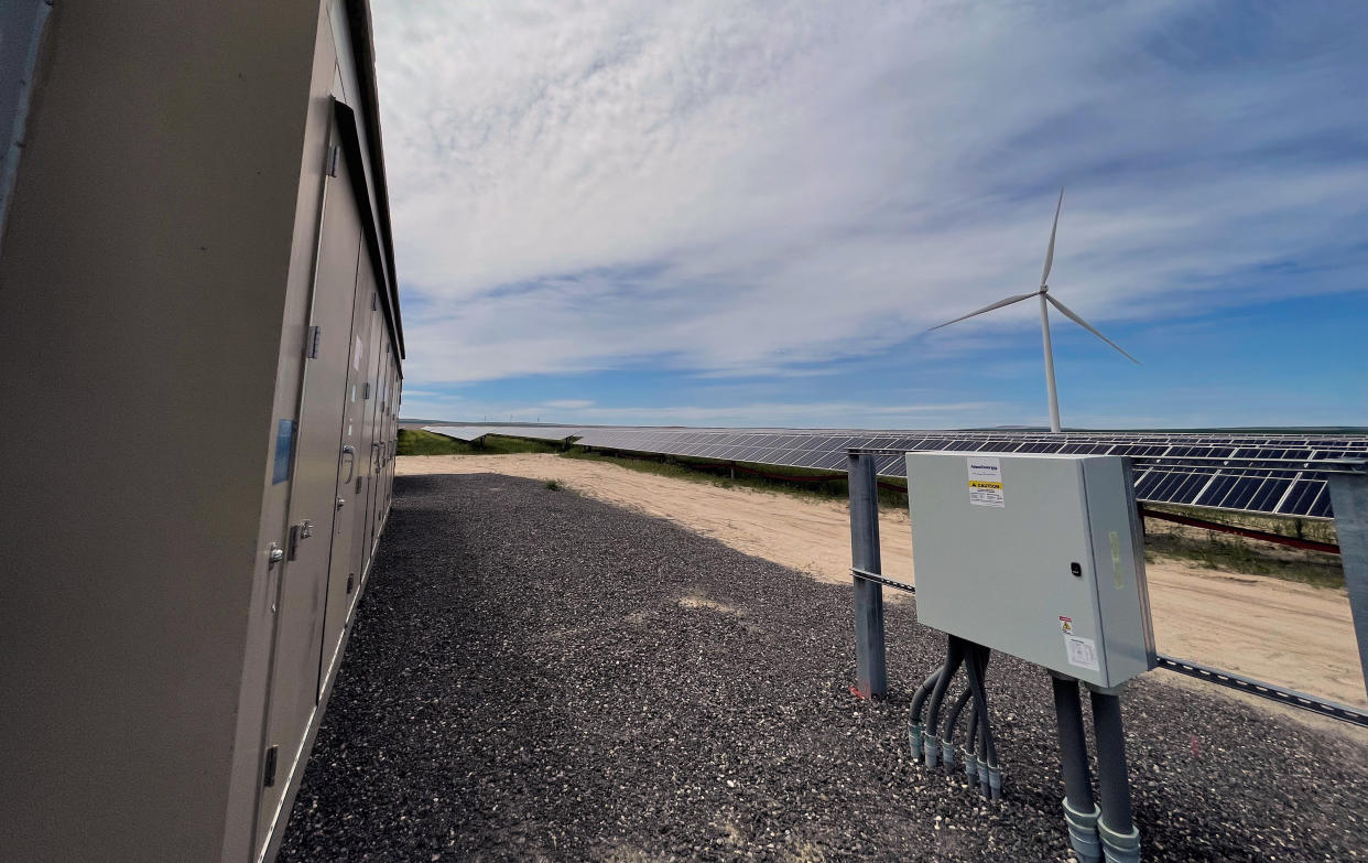 In this photo provided by Portland General Electric, windmills and solar panels are seen on May 24, 2022, at a renewable energy facility in Lexington, Ore., that combines solar power, wind power and massive batteries to store the energy generated there. The Wheatridge Renewable Energy Facilities was commissioned Wednesday, Sept. 28, 2022, and is the first utility-scale plant of its kind in North America. Clean energy experts say the project, which can power 100,000 homes, addresses some key challenges facing the industry as the U.S. transitions away from fossil fuels. (Sarah Hamaker/Portland General Electric via AP)