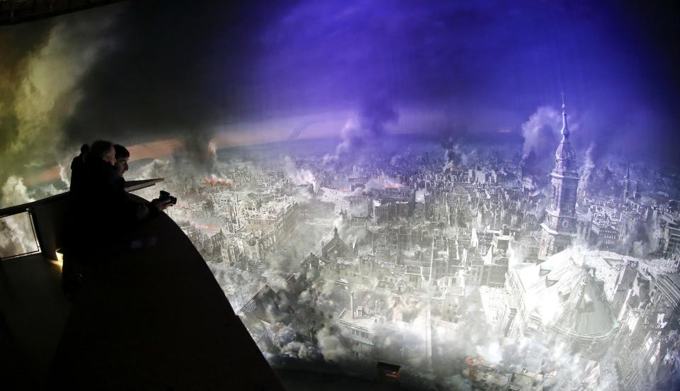 Visitors watch from a platform the 'Dresden 1945' 360 degrees panorama showing the destroyed city of Dresden after the bombing raids during the World War Two in February 1945 at the Panometer in Dresden