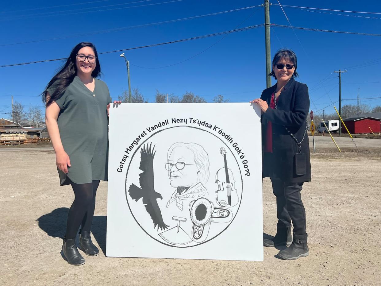 Erin Sullivan, left, and Joyce McLeod, right, hold up a sign for the new daycare space in Fort Providence, N.W.T. (Hilary Bird/CBC - image credit)