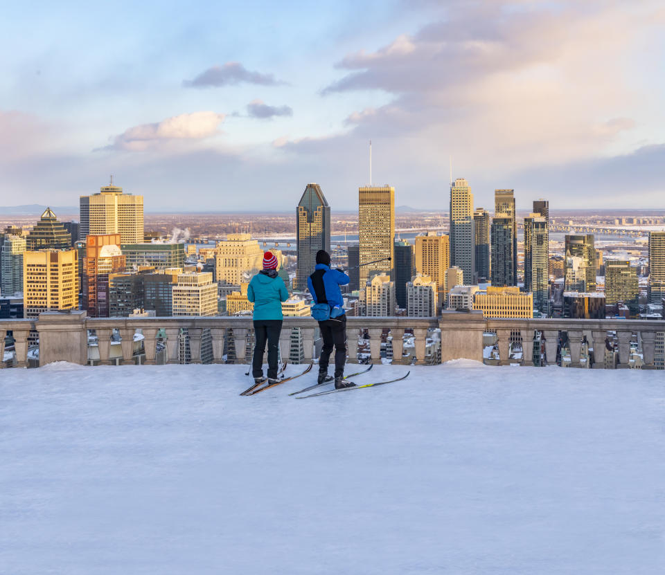 Cross-country skiers point out the Montreal skyline from the Belvedere lookout at the top of Mont Royal