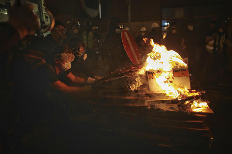 Protesters push a burning cart during a clash with police on the streets of Hong Kong on Sunday, July 28, 2019. Police fired tear gas at protesters in Hong Kong on Sunday for the second night in a row in another escalation of weeks-long pro-democracy protests in the semi-autonomous Chinese territory. (Elson Li/HK01 via AP)