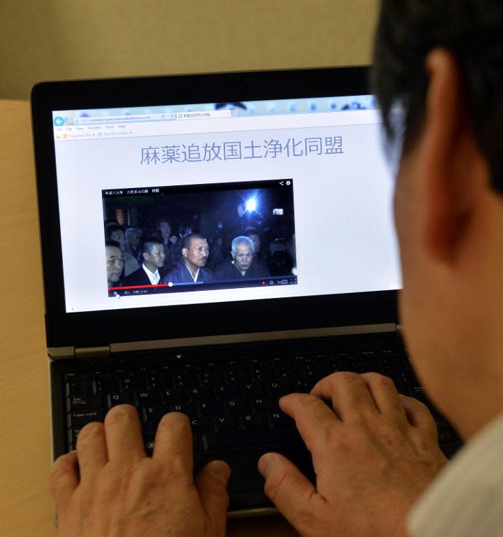 A web user uses a laptop to browse the "Banish Drugs and Purify the Nation League" website displaying a video image of Kenichi Shinoda, the boss of the Yamaguchi-gumi, Japan's largest yakuza grouping, in Tokyo, on April 2, 2014