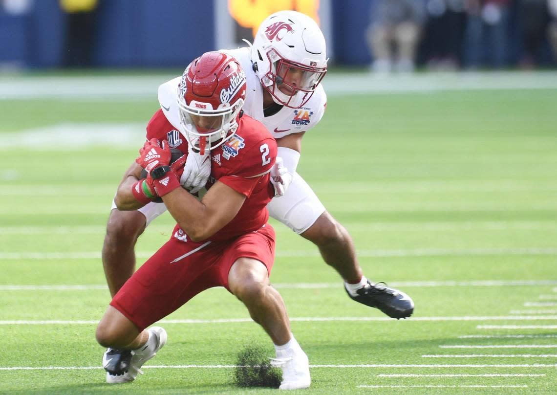 Washington State’s Jaden Hicks, background, tackles Fresno State’s Zane Pope, foreground, at the Jimmy Kimmel LA Bowl against Washington State Saturday, Dec. 17, 2022 in Inglewood, CA.