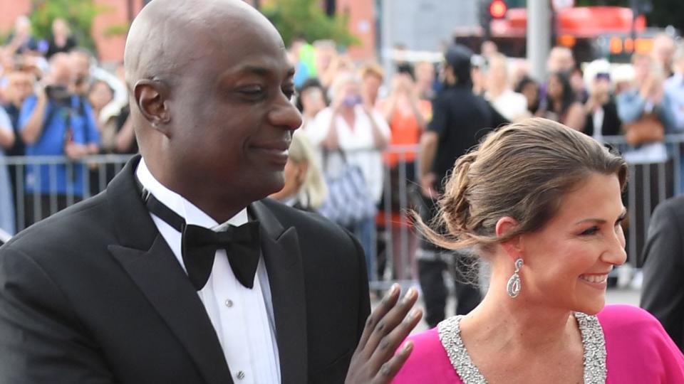 Princess Martha-Louise in a pink dress waving with Durek Verrett  