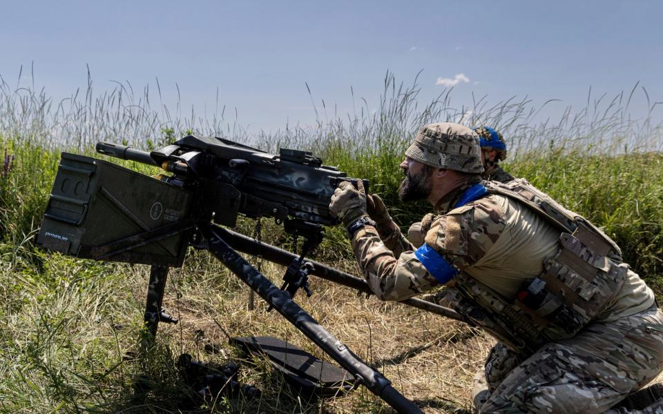 A Ukrainian serviceman aka Oduvanchik of the 3rd Assault Brigade fires a MK19 grenade launcher towards the Russian positions at the front line near Bakhmut