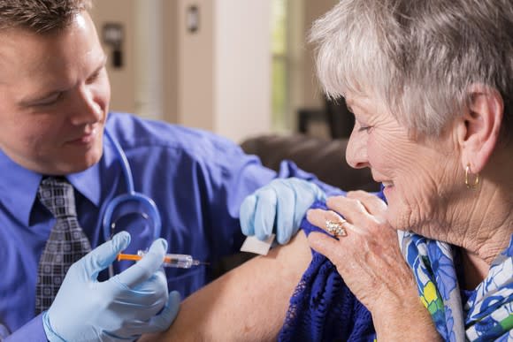 A doctor administering a flu vaccine to an elderly patient.