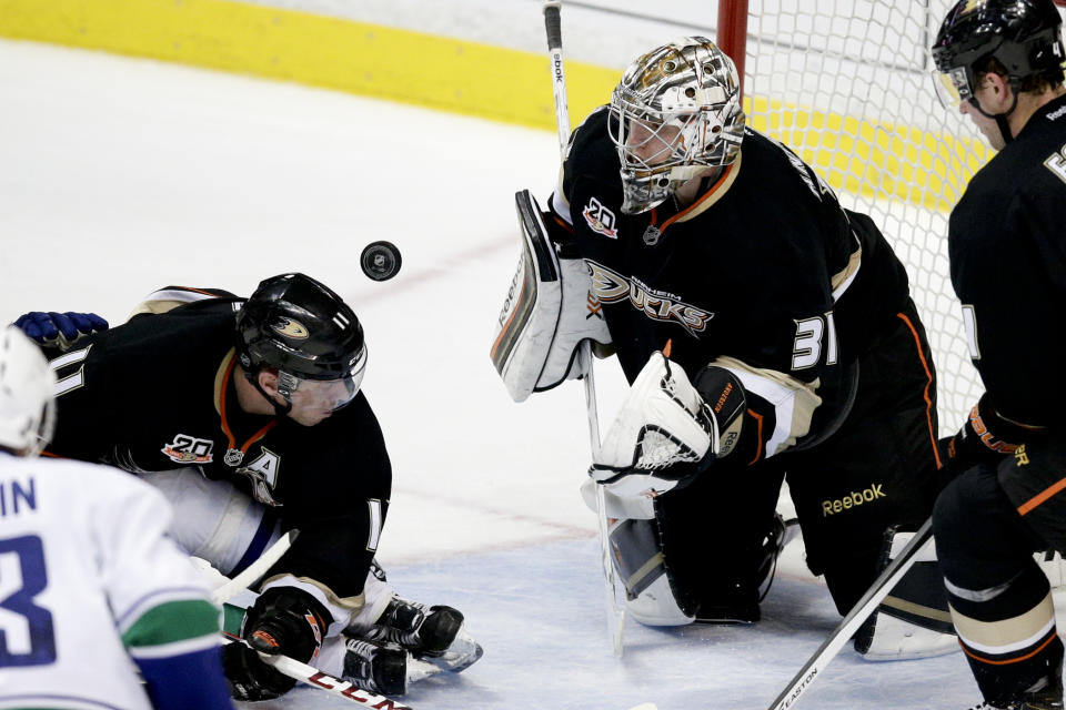 Anaheim Ducks goalie Frederik Andersen, right, of Denmark, deflects a puck in front of teammate Saku Koivu, of Finland, during the second period of an NHL hockey game against the Vancouver Canucks on Wednesday, Jan. 15, 2014, in Anaheim, Calif. (AP Photo/Jae C. Hong)