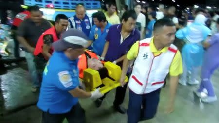 Rescuers carry an injured person on a stretcher after a boat capsized off the tourist island of Phuket, Thailand July 5, 2018 in this still image taken from video. Video taken July 5, 2018. REUTERS via Reuters TV