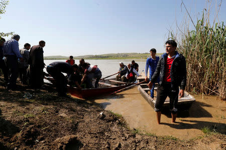 Displaced Iraqis from Mosul cross the Tigris by boat as flooding after days of rainfall has closed the city's bridges, at the village of Thibaniya, south of Mosul. REUTERS/Muhammad Hamed