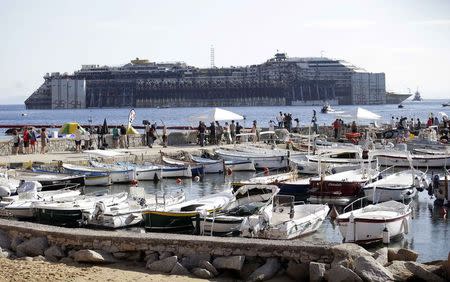 People watch the cruise liner Costa Concordia during the refloat operation maneuvers from the Giglio harbour, in Giglio Island July 23, 2014. REUTERS/ Max Rossi