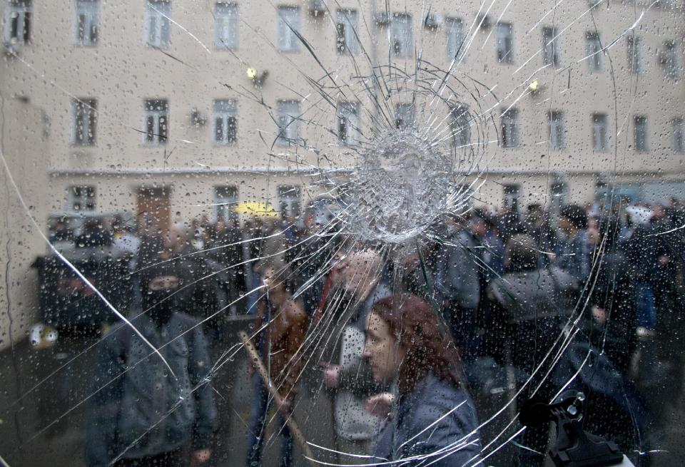 Pro-Russian protesters, seen through the cracked window of a police van, stand in the grounds of a police station in Odessa, Ukraine, Sunday, May 4, 2014. Several prisoners that were detained during clashes that erupted Friday between pro-Russians and government supporters in the key port on the Black Sea coast were released under the pressure of protesters that broke into a local police station and received a hero's welcome by crowds. (AP Photo/Vadim Ghirda)