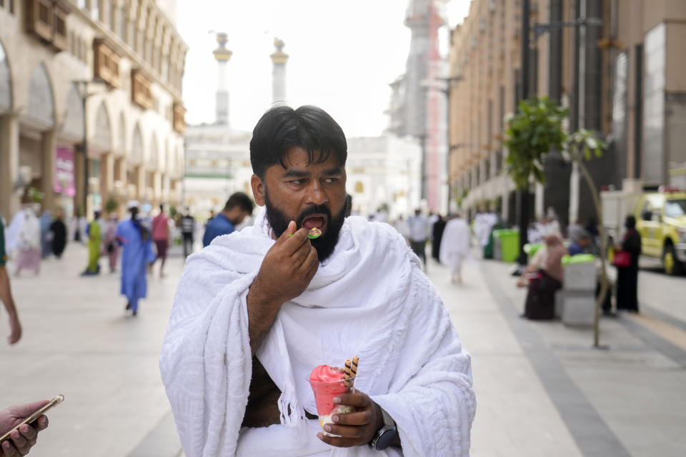 Pakistani pilgrim Muhammad Ramzan eats ice cream outside the Grand Mosque, during the annual hajj pilgrimage, in Mecca, Saudi Arabia, Saturday, June 24, 2023. Muslim pilgrims are converging on Saudi Arabia's holy city of Mecca for the largest hajj since the coronavirus pandemic severely curtailed access to one of Islam's five pillars. (AP Photo/Amr Nabil)