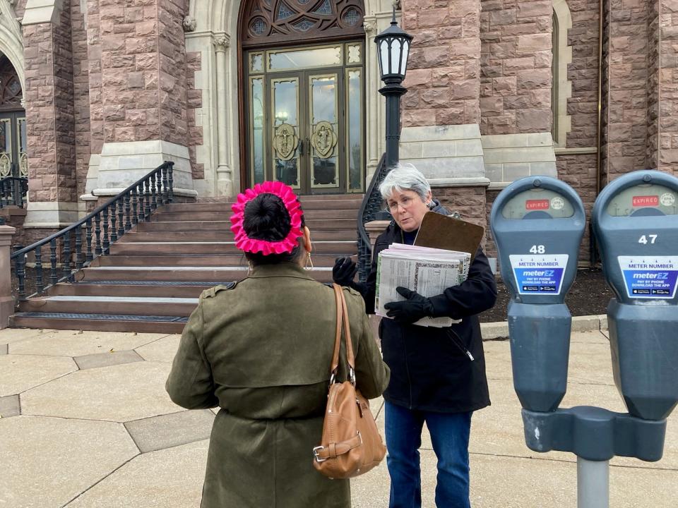 Former Erie County Public Library Director Mary Rennie, on right, talks to a resident while demonstrating outside of St. Peter Cathedral on Dec. 10, 2023. Rennie has been a vocal critic of the county-approved agreement that allows Gannon University to lease space inside Blasco Library.