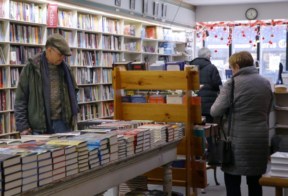 Tom Carroll, left, and other patrons browse through books Monday, Dec. 18, 2023 at Prairie Lights in downtown Iowa City, Iowa.