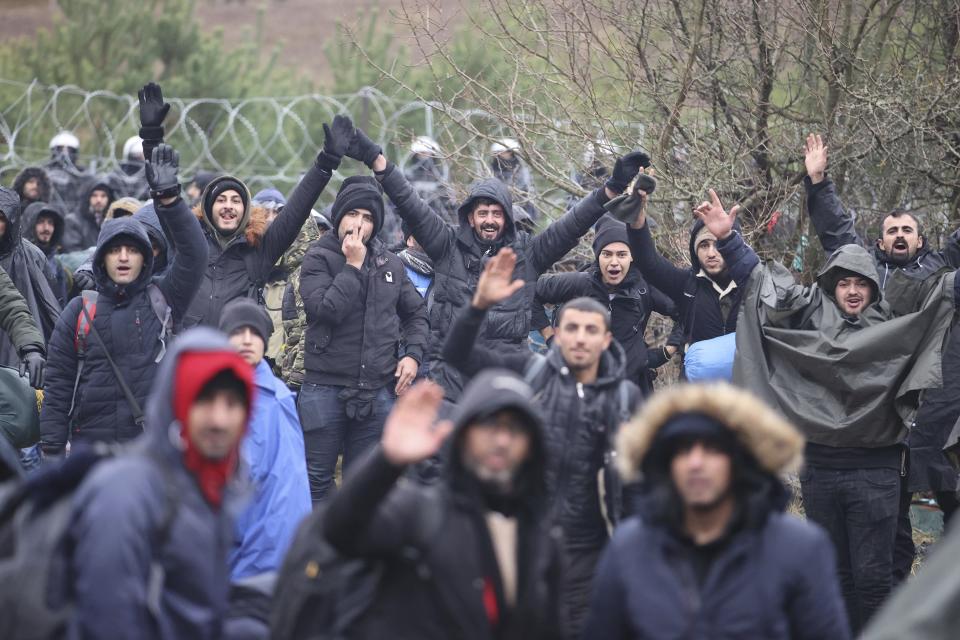 Migrants from the Middle East and elsewhere gather at the Belarus-Poland border near Grodno, Belarus, Monday, Nov. 8, 2021. Poland increased security at its border with Belarus, on the European Union's eastern border, after a large group of migrants in Belarus appeared to be congregating at a crossing point, officials said Monday. The development appeared to signal an escalation of a crisis that has being going on for months in which the autocratic regime of Belarus has encouraged migrants from the Middle East and elsewhere to illegally enter the European Union, at first through Lithuania and Latvia and now primarily through Poland. (Leonid Shcheglov/BelTA via AP)