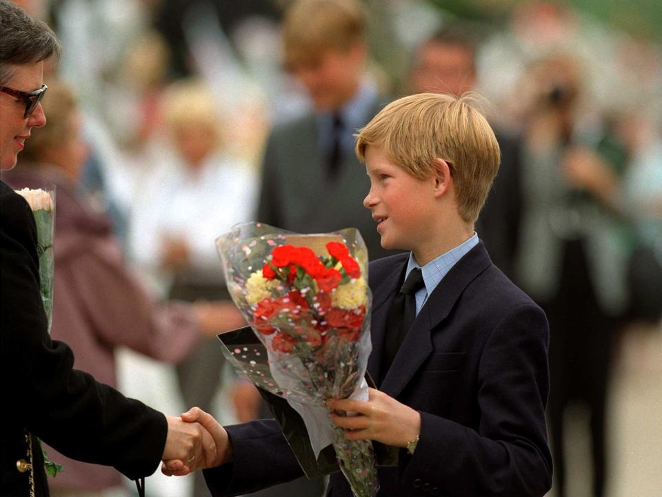 Prince Harry receiving floral tributes at Kensington Palace after the death of his mother