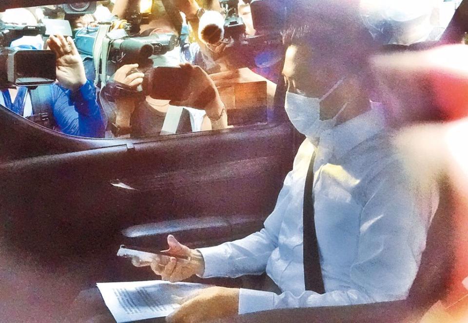 12日在總統官邸舉行的民進黨臨時選對會敲定「換堅」後，林智堅低調搭車離開時在車上看著手稿，媒體紛紛貼上車窗採訪。（資料照／姚志平攝）
