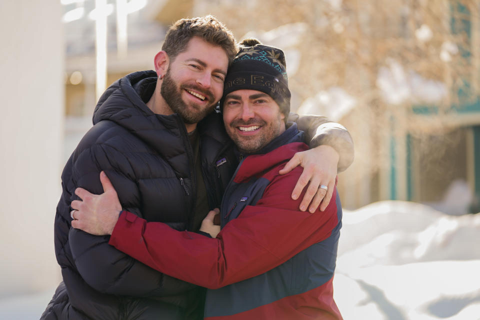 closeup of him and his husband hugging outside