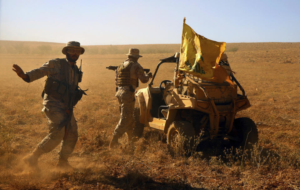 FILE - This July 29, 2017 file photo, Hezbollah fighters stand near a four-wheel vehicle positioned at the site where clashes erupted between Hezbollah and al-Qaida-linked fighters in Wadi al-Kheil on the Lebanon-Syria border. From Lebanon and Syria to Iraq, Yemen, and the Gaza Strip, Iran has significantly expanded its footprint over the past decade, finding and developing powerful allies in conflict-ravaged countries across the Middle East. Iran has used groups like the Lebanese Hezbollah to strike its regional foes, and could mobilize them if the latest tensions with the United States lead to an armed conflict, dramatically expanding the battlefield. (AP Photo/Bilal Hussein, File)