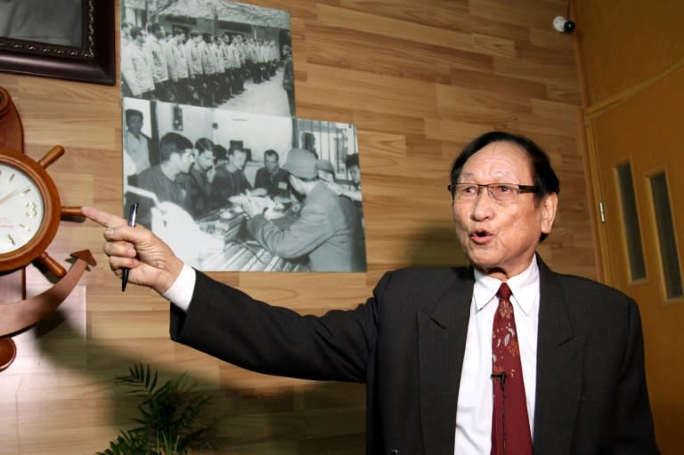 Tran Trong Duyet, John McCain's wartime jailor, points to photos of US prisoners of war on display at his home