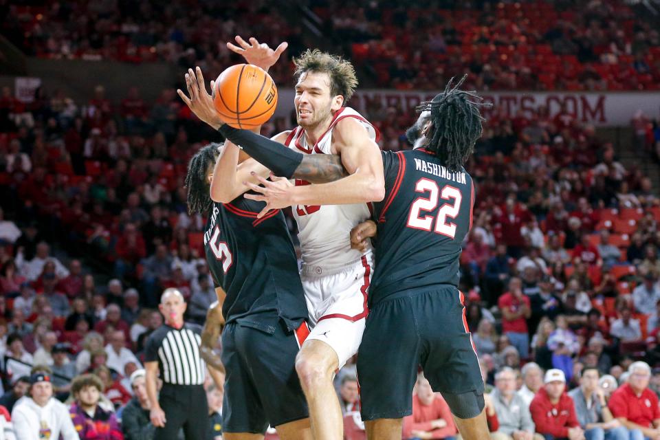 OU's Sam Godwin (10) fights for the ball with Texas Tech's Darrion Williams (5) and Warren Washington (22) in the second half Saturday at Lloyd Noble Center in Norman.