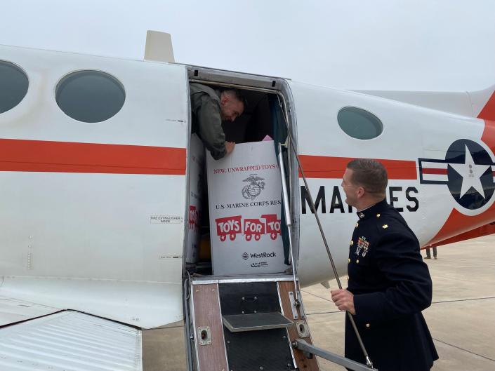 Local marines unload boxes of toy donations from an aircraft on Tuesday, Dec. 7, 2021. The donations are for Toys for Tots, an organization that gives toys to less fortunate children for Christmas.