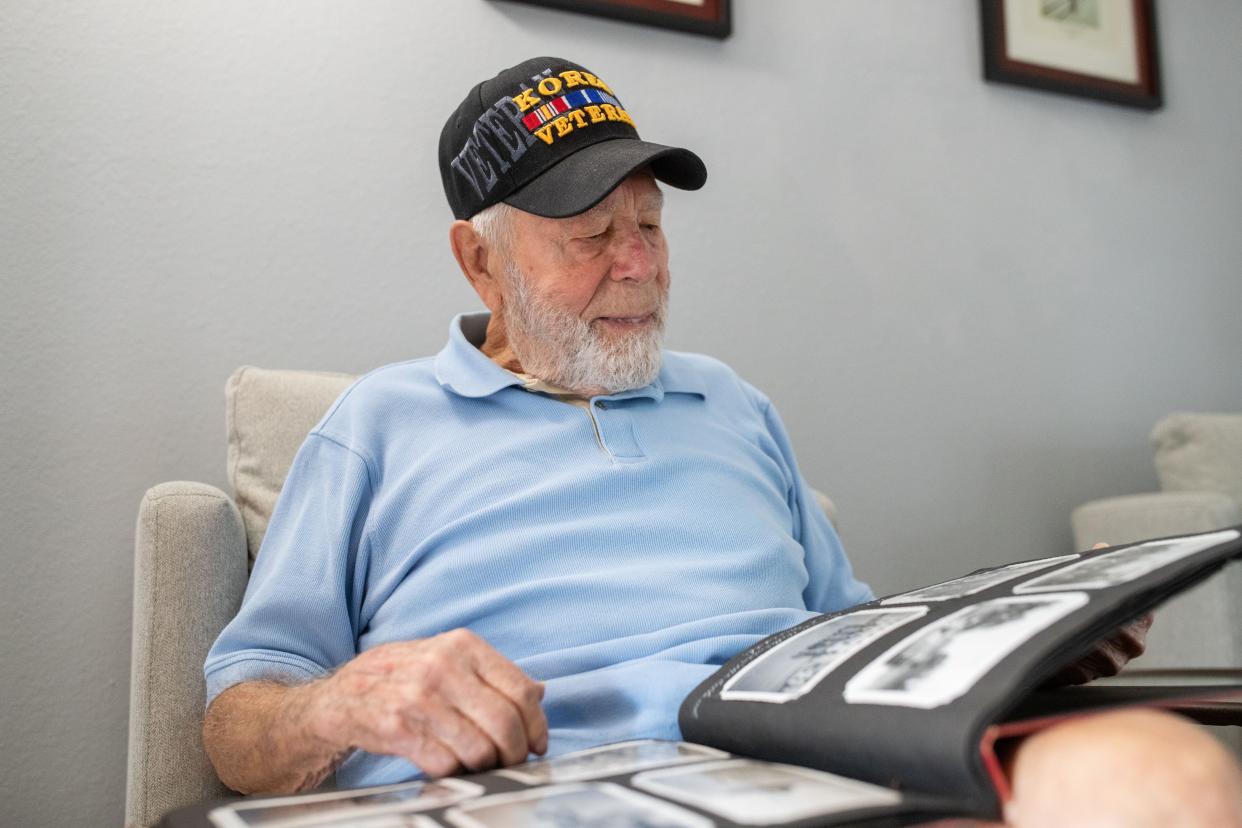 Harold Barcus reminisces on his time serving in the Korean War while looking at old photographs on Wednesday, April 10, 2024.