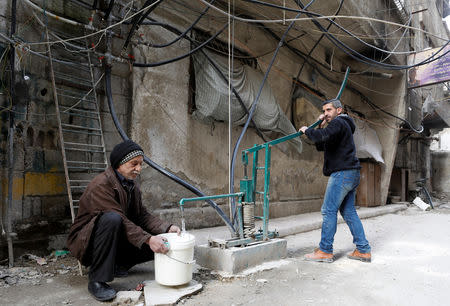 Hisham al-Zarqawi uses a hand-pump to collect water in Ein Terma, a district of eastern Ghouta, Syria February 26, 2019. REUTERS/Omar Sanadiki