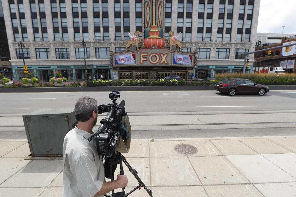 A cameraman gathers footage outside the Fox Theatre displaying signs for the Democratic presidential debates in Detroit, Monday, July 29, 2019. The second scheduled debate will be hosted by CNN on July 30 and 31. (AP Photo/Paul Sancya)