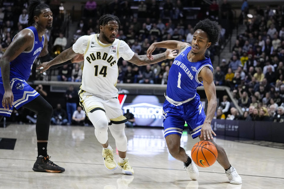 New Orleans guard Jordan Johnson (1) drives on Purdue guard David Jenkins Jr. (14) during the first half of an NCAA college basketball game in West Lafayette, Ind., Wednesday, Dec. 21, 2022. (AP Photo/Michael Conroy)