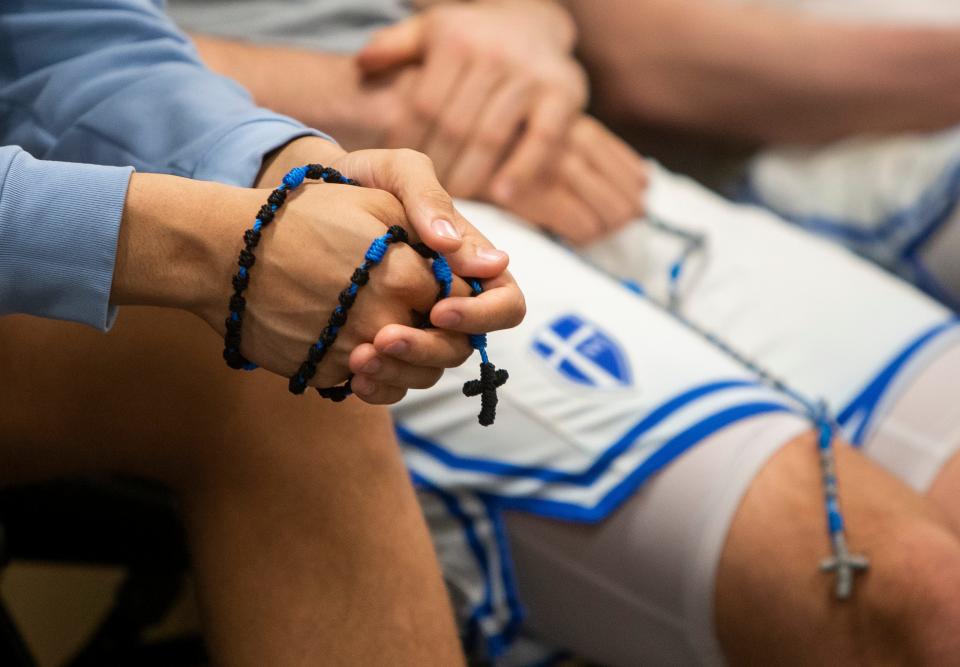 Marian players and coaches pray the Rosary in the locker room before the 3A boys basketball state championship game on Saturday, March 26, 2022, at Gainbridge Fieldhouse in Indianapolis. 