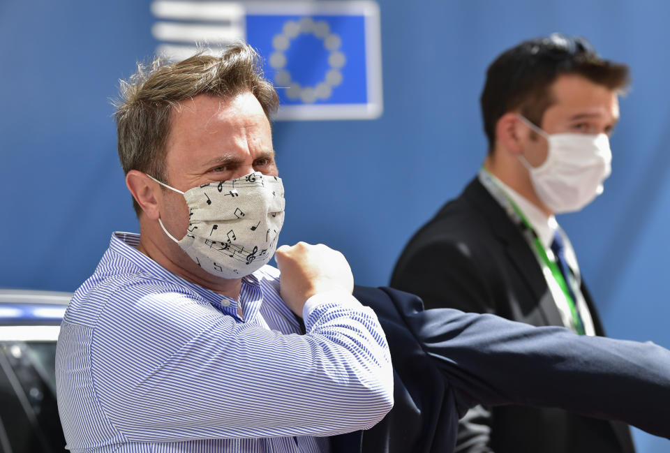 Luxembourg's Prime Minister Xavier Bettel, left, arrives at the European Council building for an EU summit in Brussels, Sunday, July 19, 2020. Leaders from 27 European Union nations meet face-to-face for a third day to assess an overall budget and recovery package spread over seven years estimated at some 1.75 trillion to 1.85 trillion euros. (John Thys, Pool Photo via AP)