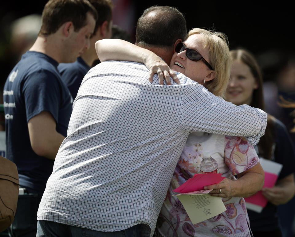 Attendees hug before a program for the victims of the massacre at Columbine High School 20 years ago Saturday, April 20, 2019, in Littleton, Colo. (AP Photo/David Zalubowski)