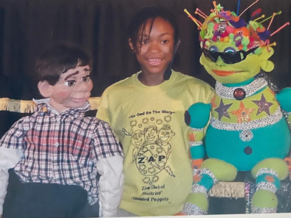 Megan Piphus as a child, performing with two puppets.