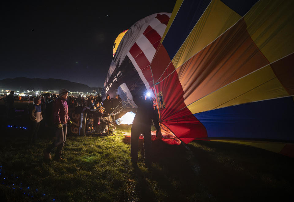 Balloonists begin to inflate their balloons for the start of the 51st Albuquerque International Balloon Fiesta in Albuquerque N.M., on Saturday, Oct. 7, 2023. (AP Photo/Roberto E. Rosales)
