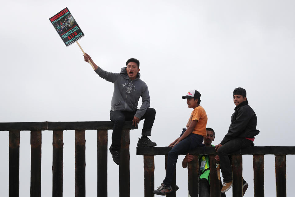 Members of a migrant caravan from Central America and their supporters sit on the U.S.-Mexico border at Border Field State Park before making an asylum request in San Diego in April. (Photo: Lucy Nicholson/Reuters)