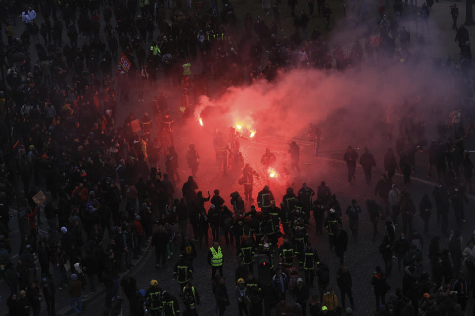 Protesters uses flares during a demonstration, Tuesday, March 7, 2023 in Paris. Hundreds of thousands of demonstrators across France took part Tuesday in a new round of protests and strikes against the government's plan to raise the retirement age to 64, in what unions hope will be their biggest show of force against the proposal. (AP Photo/Aurelien Morissard)