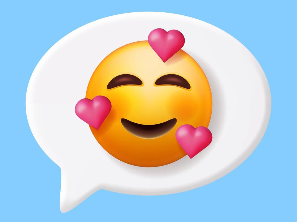 a conversation bubble with a smiling emoji with pink hearts surrounding it