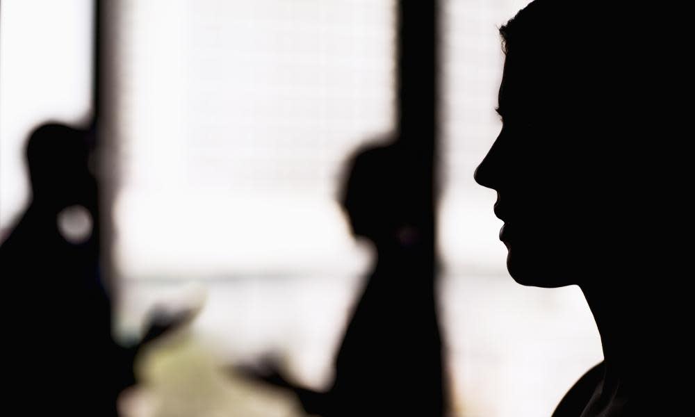 A silhouette of a businesswoman with coworkers in the background.