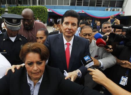 Alejandro Moncada Luna (C) is escorted by police as journalists try to interview him after he appeared in front of a congressional committee in Panama City October 20, 2014. REUTERS/Stringer