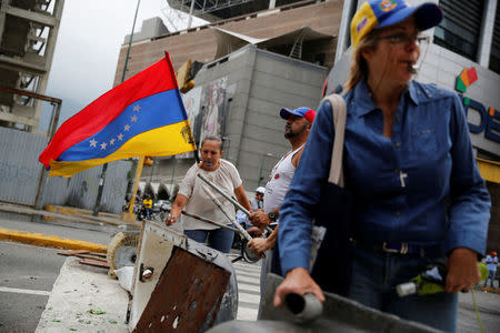 Opposition supporters bang a metal barricade during a rally against Venezuela's President Nicolas Maduro in Caracas, Venezuela April 24, 2017. REUTERS/Carlos Garcia Rawlins