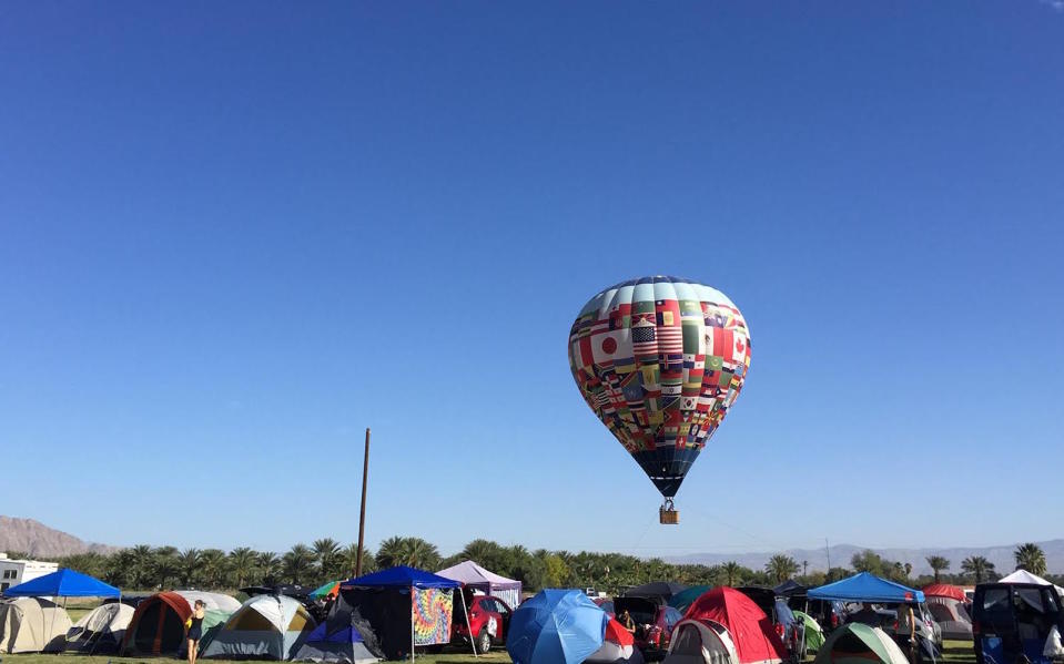 Hot air balloons rise over tents at Base Camp at the Coachella Music Festival